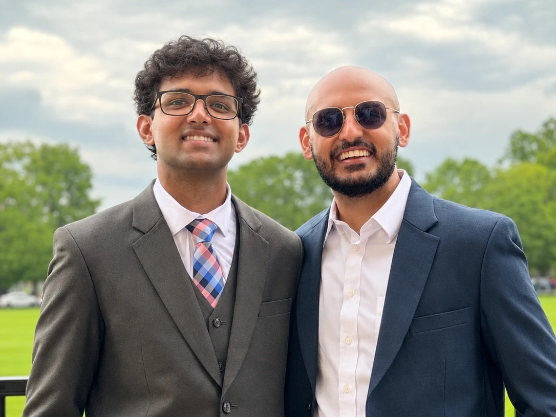Deepaksh and Etash Kalra standing together outdoors in suits